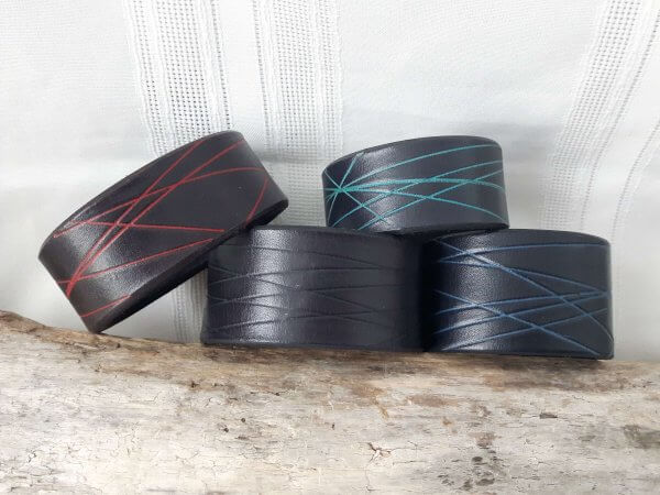 Bracelets de cuir noirs avec motifs linéaires colorés